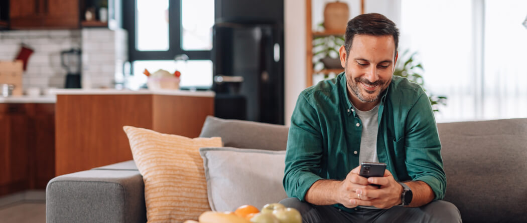 Man using mobile phone on couch 