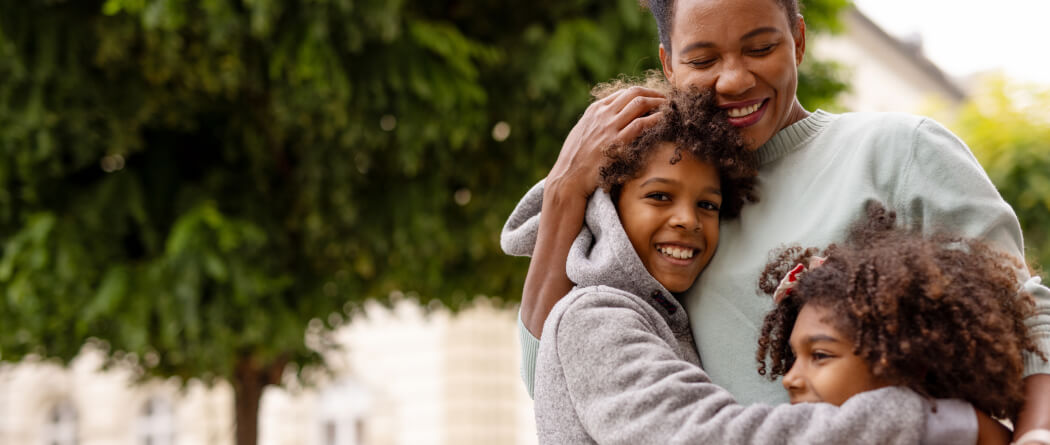 mother hugging two kids